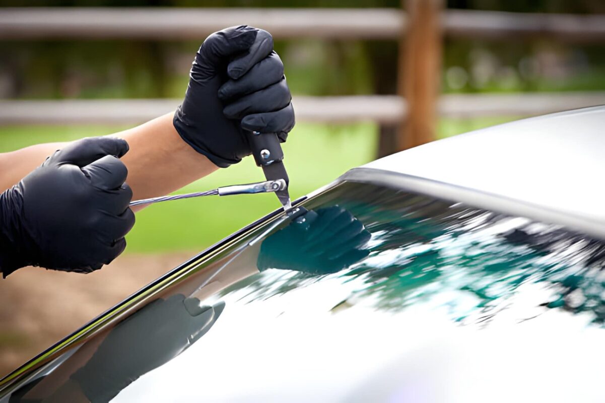 Technician inspecting windshield damage to determine whether auto glass repair or replacement is needed in New Jersey