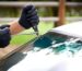 Technician inspecting windshield damage to determine whether auto glass repair or replacement is needed in New Jersey